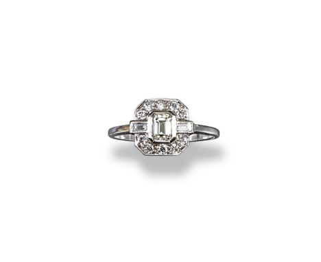 A diamond cluster ring, the centre emerald cut diamond is set within a surround of circular-cut and baguette-shaped diamonds 