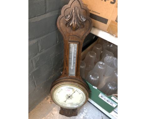 A carved oak aneroid barometer 