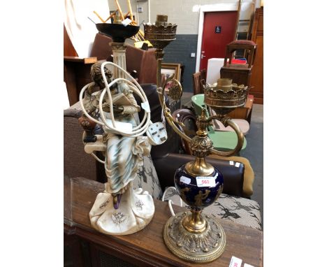 A porcelain and brass table lamp together with a resin figural lamp. 