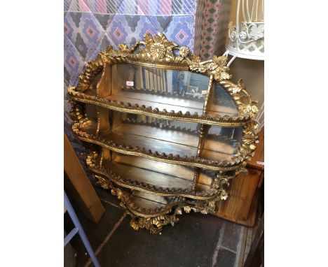 A five tier ornate mirror backed shelf, approx. 105cm x 115cm. 