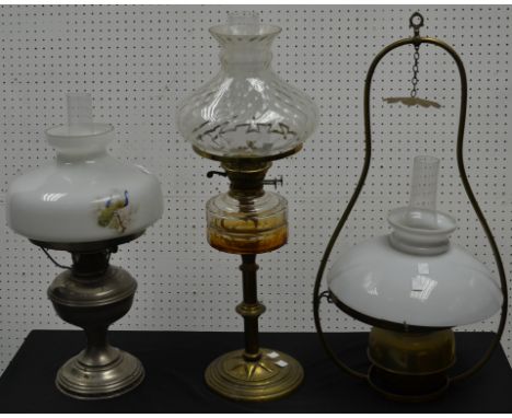 A brass oil ceiling lantern; a oil lamp with amber glass reservoir; another. (3)