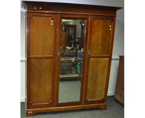 A Victorian mahigany triple wardrobe, outswept cornice, central mirrored door flanked by panel doors, bracket feet. 208cm hig