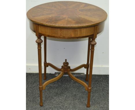 An Edwardian circular occasional table segmented walnut veneered top inlaid with satinwood harebells, deep frieze, turned tap