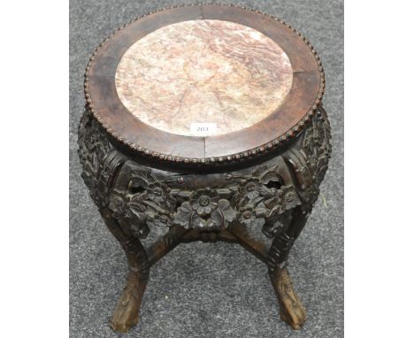 A late 19th century Chinese hardwood jardiniere stand, inset soapstone circular top, beaded border above friezes boldly carve
