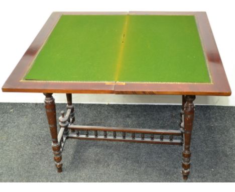 A Victorian mahogany card table, fold over top opening to green baize playing surface, turned legs, spindled H-stretcher.