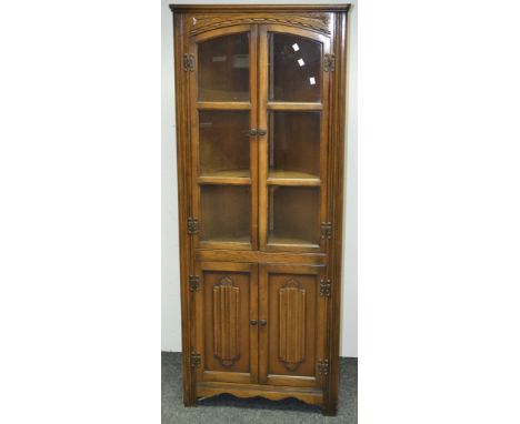 An Old Charm oak floor standing corner display cabinet, two three light doors to top, linenfold doors to base. 167cm high x 6