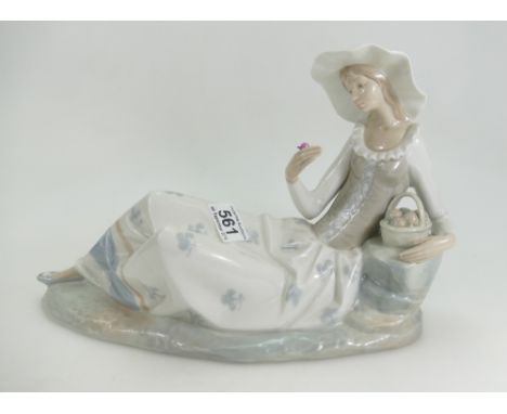 Large Nao figure of a lady reclining on a rock holding a flower, h23cm, L38cm