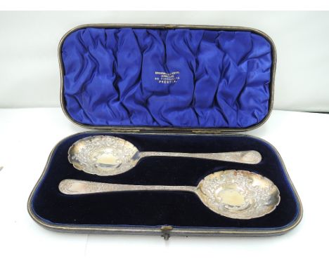 A cased pair of silver berry spoons having frilled edging to gilt bowls and extensively engraved handles, London 1901, Willia
