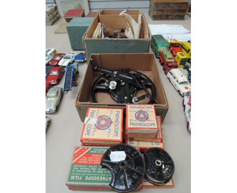 A vintage pathescope 'IMP' projector in origional boxes and a selection of reels and instruction paper