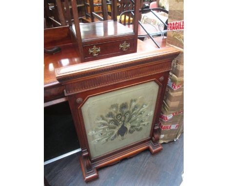 A late 19th century mahogany frame firescreen having chip carved and roundel decoration with inset silk panel having peacock 