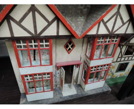 A vintage wooden two tier dollshouse having fitted fireplace and curtains and tin plate windows