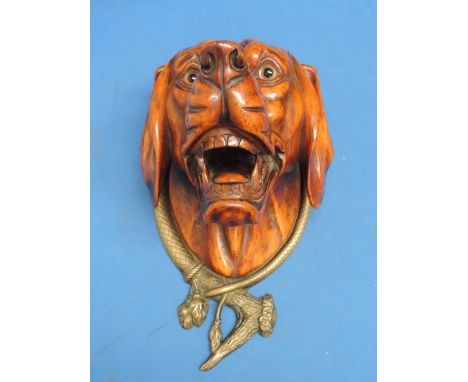 A late 19th century treen wall mask modelled as sporting dog with ornate brass mount of hunting theme