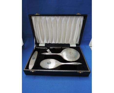 A cased silver backed four piece dressing table set having engine turned decoration and plain cartouche, Birmingham 1971, W I