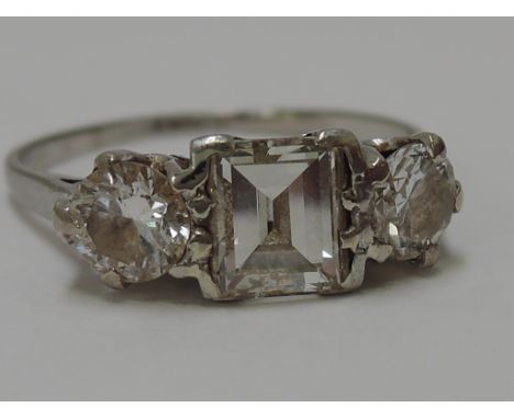 A ladies three stone dress ring having a central square cut diamond flanked by two further circular diamonds,  approx 1ct, on