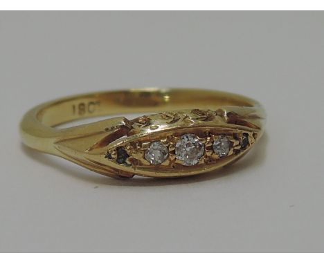 A ladies dress ring having five graduated diamonds in an engraved gallery mount on a yellow metal loop stamped 18CT