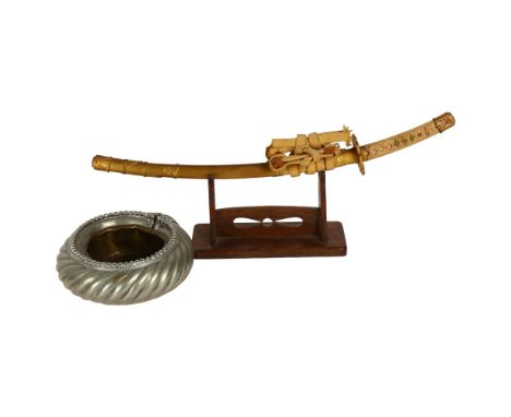 A desk-top study of a Japanese Samurai Tanto, on stand, L36cm, and an African slave bangle made into an ashtray 