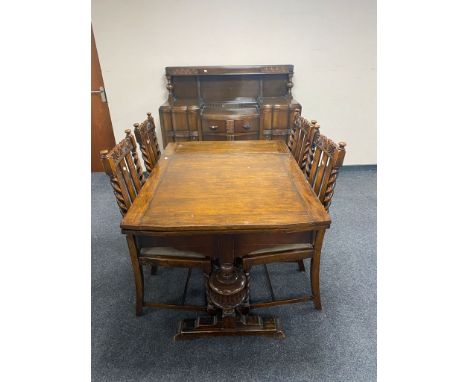 A six piece early 20th century oak dining room suite comprising of buffet back sideboard, extending table and four barley twi