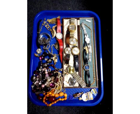 A tray of a collection of costume jewellery to include beaded necklaces, brooches, simulated pearls, enamel transport badges 