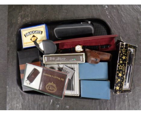 A tray containing miscellaneous to include pens, vintage money boxes in the form of books, hip flask, wallet sets, harmonica 