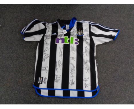 A vintage Newcastle United football shirt bearing many signatures including Sir Bobby Robson, Alan Shearer, Shay Given, Andy 