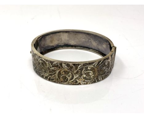 An antique white metal hinged bangle, likely silver though unmarked. 