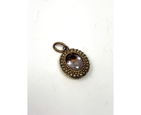 An antique yellow metal pendant set with split pearl and amethyst