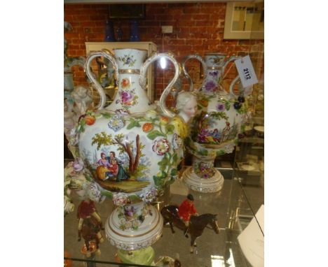 A pair of Continental Meissen style twin handle baluster vases. Each with portrait buts applied to shoulders, polychrome rais
