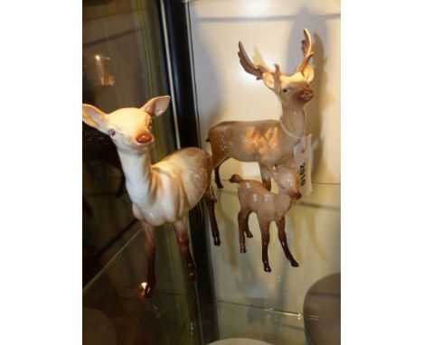 Three Beswick pottery figures of deer, a stag, a doe and a fawn. height of largest 9cm