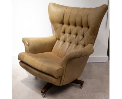 A mid-century G Plan 'Blofeld' model 62 swivel armchair, upholstered in light brown material, on castors. W 90cm, D 90cm, H 1