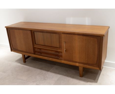 Mid century Danish teak sideboard c1960s. Central drop down front drinks cabinet fitted with manual on/off light, two felt li