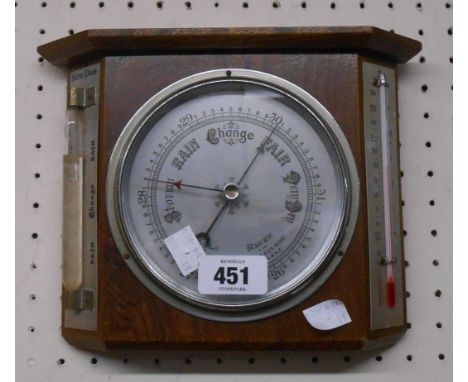 A vintage oak framed wall barometer/thermometer with storm glass and aneroid works