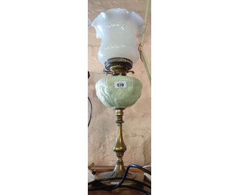 A Victorian oil lamp with cast brass candlestick form column and opaque glass reservoir with moulded Art Nouveau thistle desi
