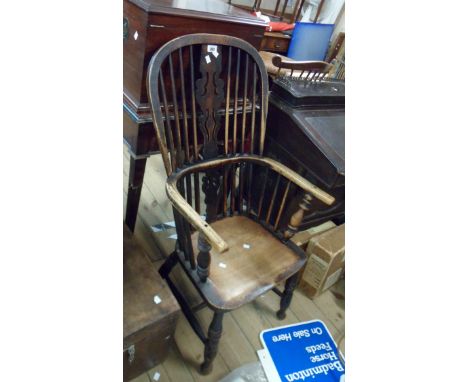 An antique Windsor hoop stick back elbow chair with moulded solid elm seat, set on turned supports - wear