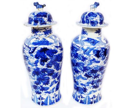 A pair of Chinese porcelain lidded vases of tall form with blue painted decoration depicting butterflies amidst foliage - fou