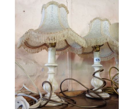 A pair of carved wooden lamps of candlestick form with painted finish - sold with shades