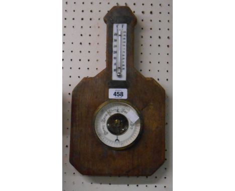 A vintage wall barometer with thermometer scale and visible aneroid works, set on a rustic wooden plaque