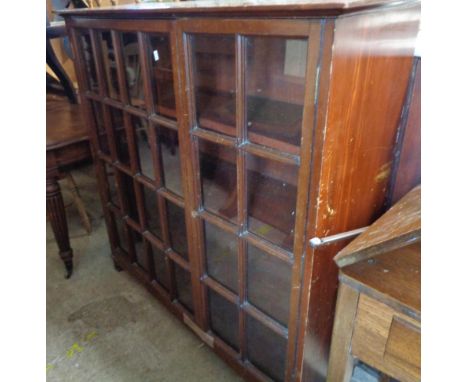 A pair of 1.18m Edwardian walnut and stained mixed wood book cabinets with adjustable shelves enclosed by a pair of beaded gl