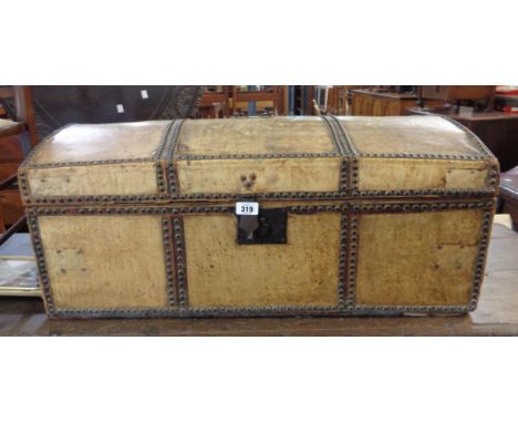 An 82cm antique studded vellum clad dome-top travelling trunk with flanking iron drop handles and material lined interior - a