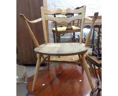 A vintage Ercol Model 493 light elm elbow chair with shaped double back rail and moulded solid seat, set on tapered supports 