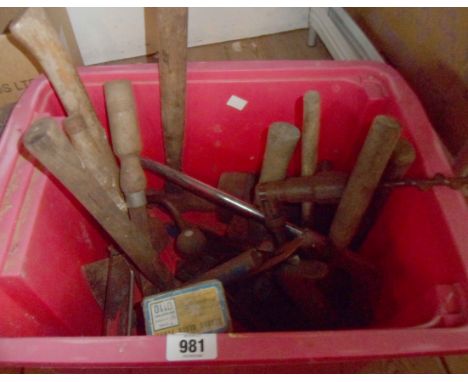 A crate containing old tools including planes, etc.