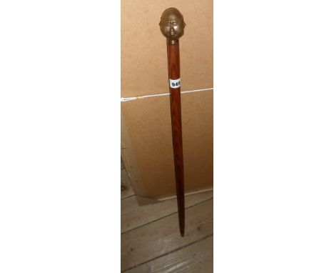 A modern walking stick with cast brass oriental style four face handle