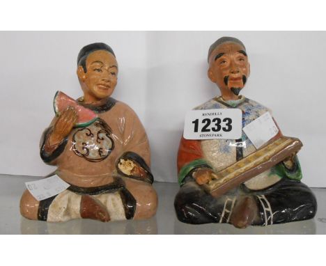 A pair of old Chinese pottery nodding head figurines, one depicting a gentleman using an abacus, the other eating a slice of 