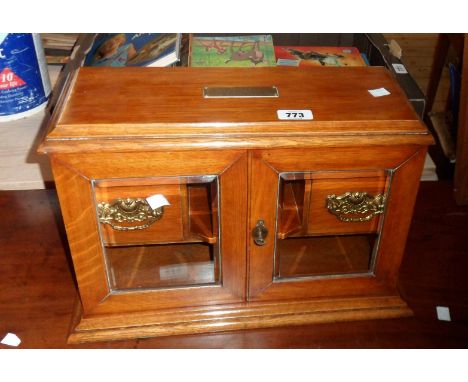 An early 20th Century oak smoker's companion of lift-top form with double front opening door enclosing two drawers, pipe rack