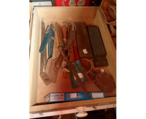 A drawer containing joinery sharpening tools and veneer saws, etc.