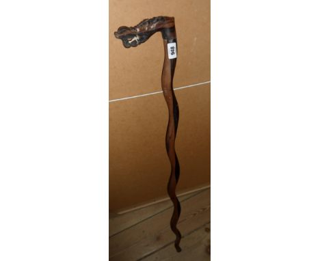 An old Eastern walking stick, the handled carved as the head of a dragon with inset bone eyes and teeth