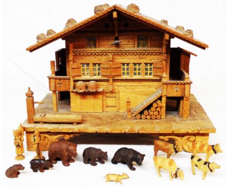 A Black Forest carved wood chalet form trinket box containing a quantity of miniature carved figures and animals including be