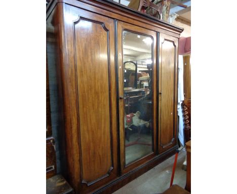 A 2.08m Victorian mahogany and ebony beaded triple wardrobe with central mirror panel door enclosing linen slides and three d