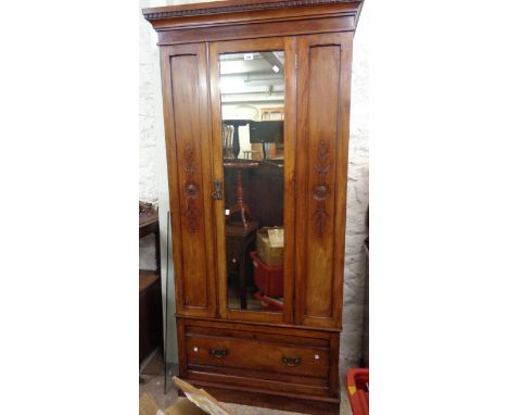 A 95cm early 20th Century stained mahogany single wardrobe with hanging space enclosed by a mirror panel door with long drawe