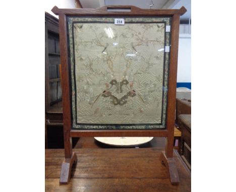 An antique Chinese silk embroidery panel, set in an oak fire screen under glass
