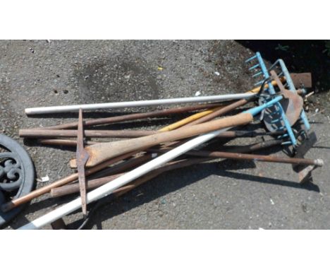 A quantity of garden tools including hoes, rakes, etc.